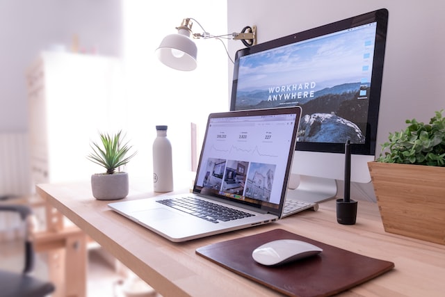 Cozy home office setup with a laptop on a desk, laptop, monitor and a plant. Work-related tax relief