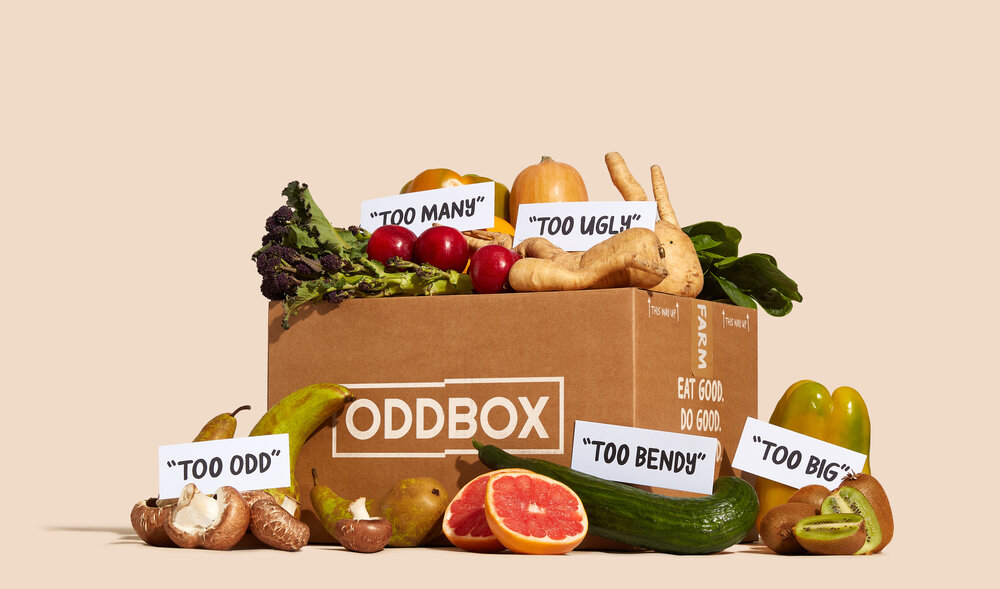 A box filled with an assortment of fresh fruits and vegetables, including apples, carrots, and broccoli.