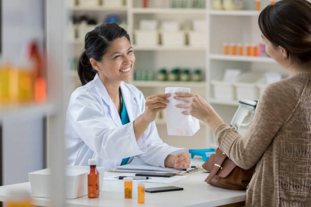 Pharmacist handing a prescription to a customer at a pharmacy counter