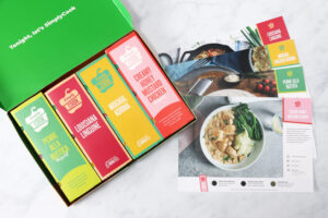 A simply cook meal kit with fresh ingredients and recipe cards.