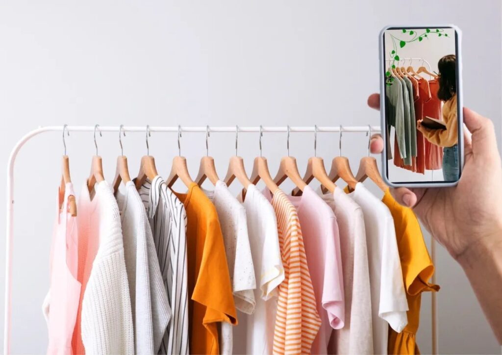 A well-organized wardrobe with neatly hung clothes, with a smartphone screen showing the Vinted app interface.