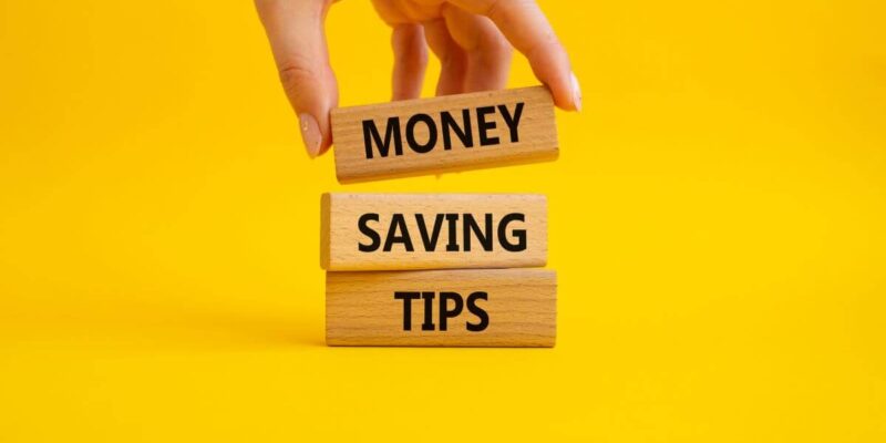 Three wooden blocks with the words "money," "saving," and "tips" written on them.